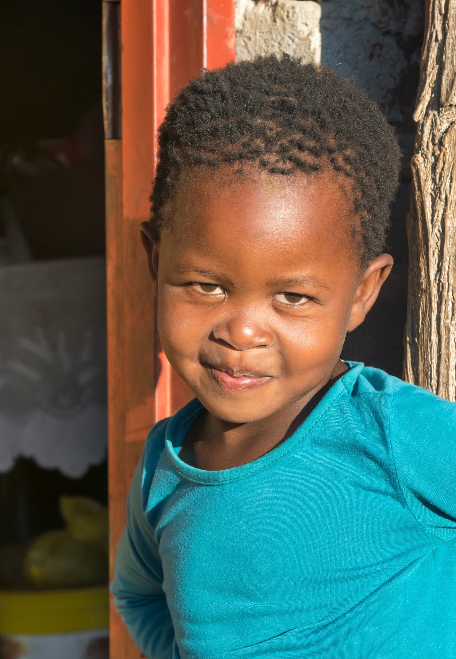 African,Village,Child,Standing,In,Front,Of,Her,Mud,House